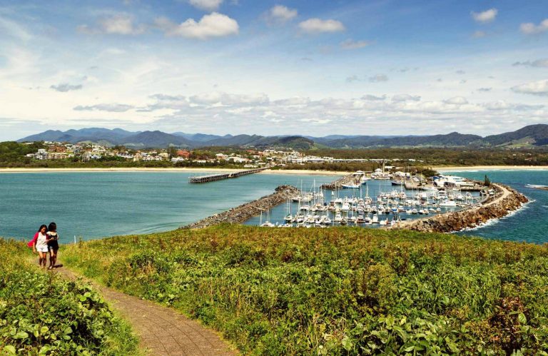 Two people enjoying the view of the Muttonbird Island Nature Reserve marina. Photo: Rob Cleary