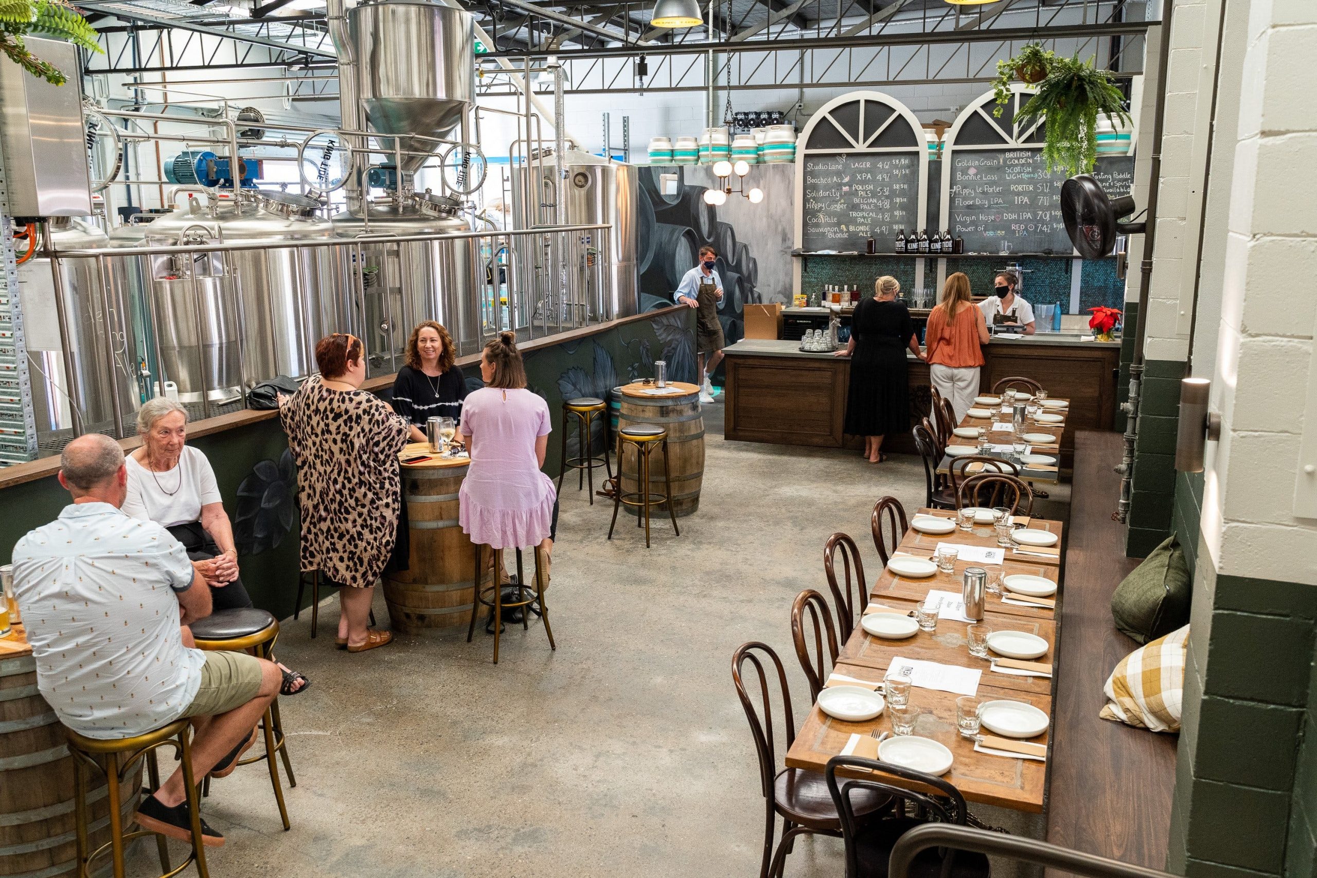 bar and brewery equipment with people sitting at the barrels