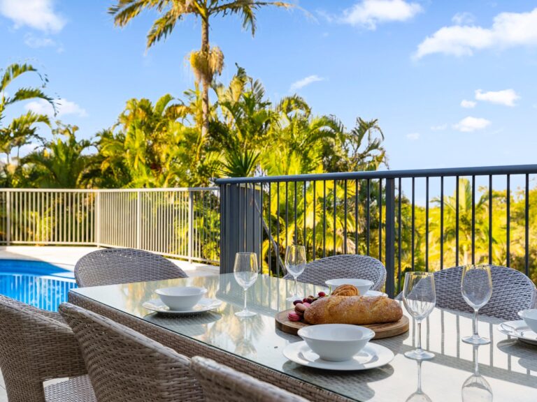 Outdoor dining with BBQ and pool views