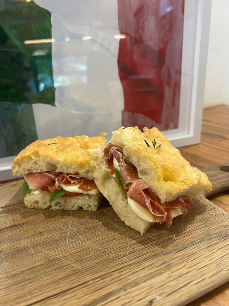 Homemade focaccia with fresh mozzarella, prosciutto, tomato and basil mayo