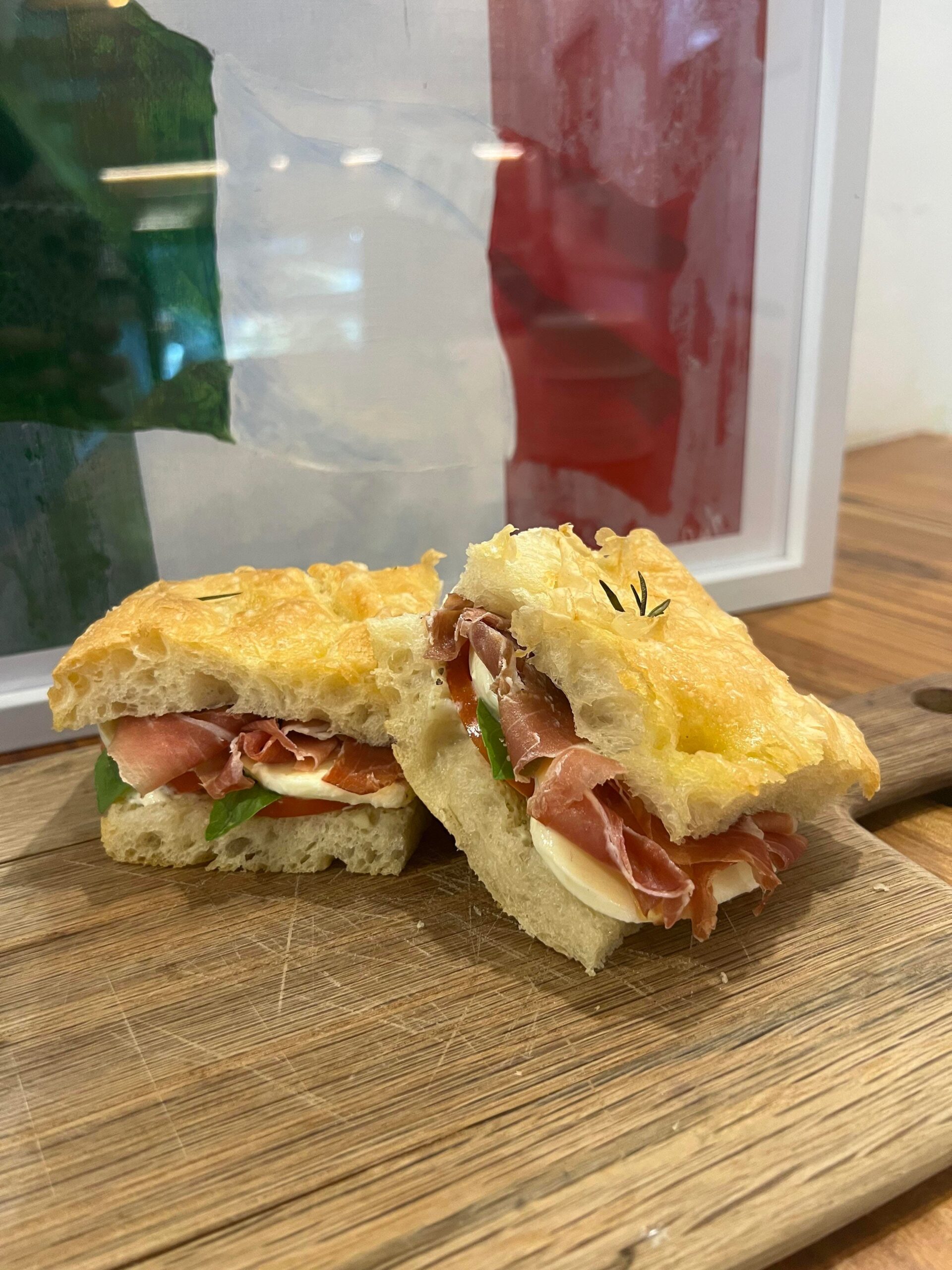 Homemade focaccia with fresh mozzarella, prosciutto, tomato and basil mayo