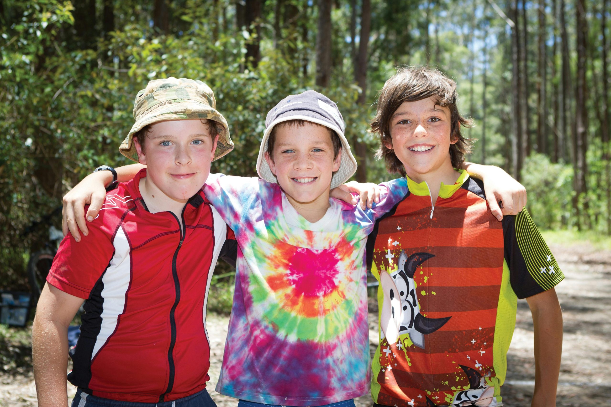 Three boys in Pine Creek State Forest smiling at the camera